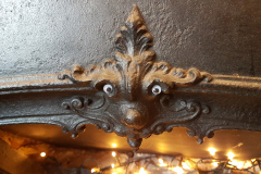Eyes stuck onto the ornate moulding at the centre of a fireplace so it looks like a dragon