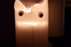 Picture of a candle with googley eyes stuck on it to make a face.