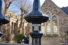 Picture of eyes stuck onto the top of a set of railings so it looks like it's wearing a hat.
