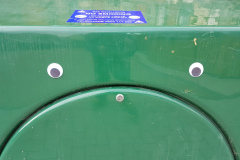 Big green plastic box with eyes stuck on so it looks like a miserable mouth